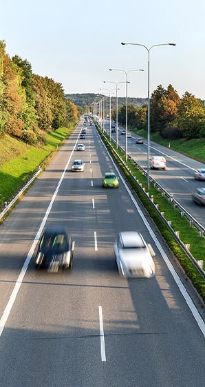 cars driving down roadway in traffic