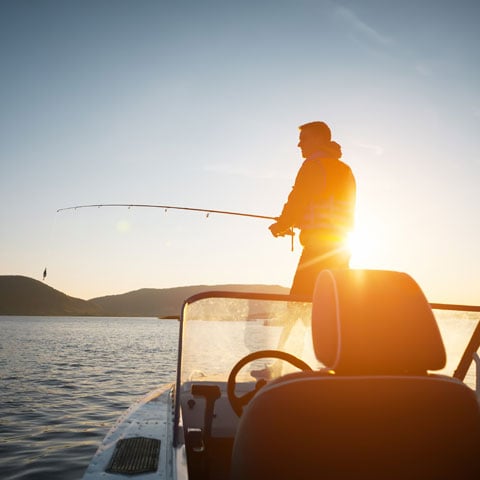 boat-loan-rates-at-allegiance-credit-union-are-affordable-man-fishing-off-his-boat-in-a-lake-at-sunset