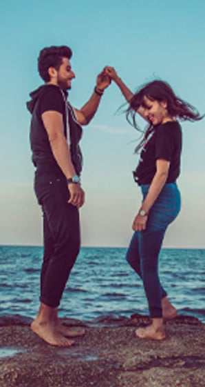 A HELOC offers this couple dancing on a rock by the ocean added security.