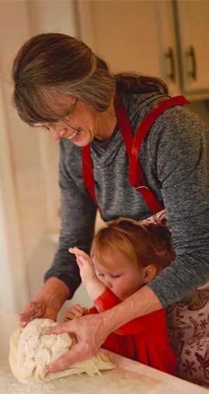 woman flouring dough with child