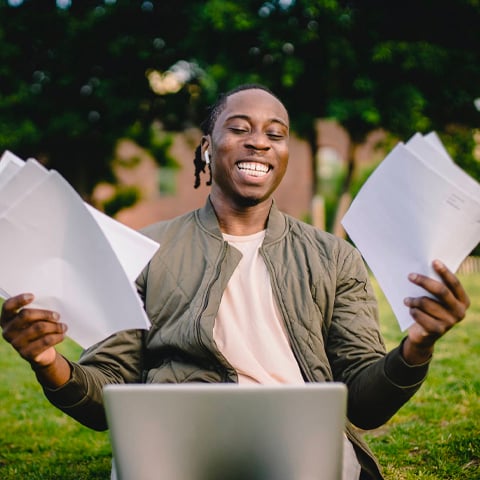 Debt consolidation was possible for this man holding his bills near a laptop after he was approved for a Home Equity Loan.