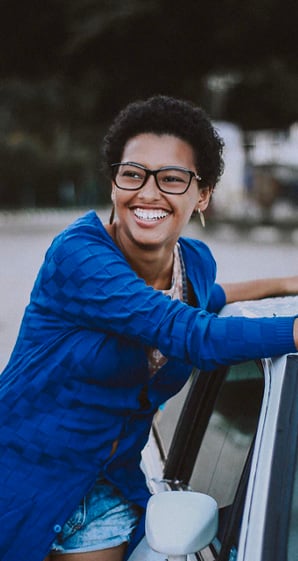 woman smiling besides car