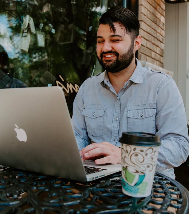 man in gray denim dress shirt on his laptop